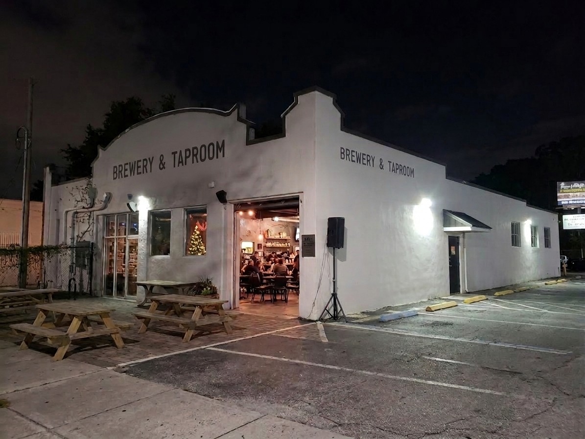 The brewery and taproom at 1012 West Church Street, Orlando, lit from within after dark.