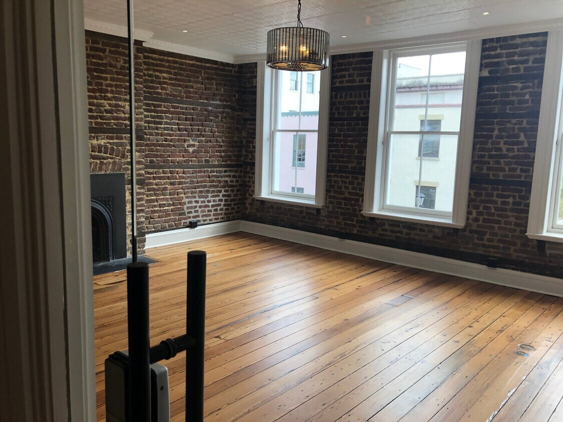 An office in the King Street building in Charleston: exposed brick walls, tall sash windows and heart pine floors.