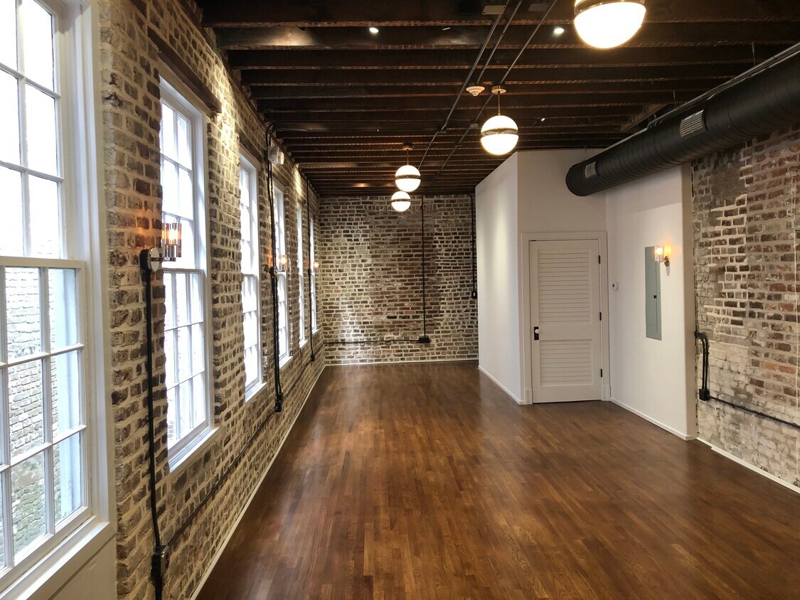 The exposed brick hall inside the King Street Offices in downtown Charleston, a building the firm owns.