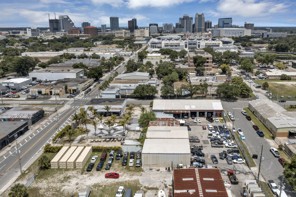 Aerial over the West Pine Street buildings with the downtown Orlando skyline behind them.